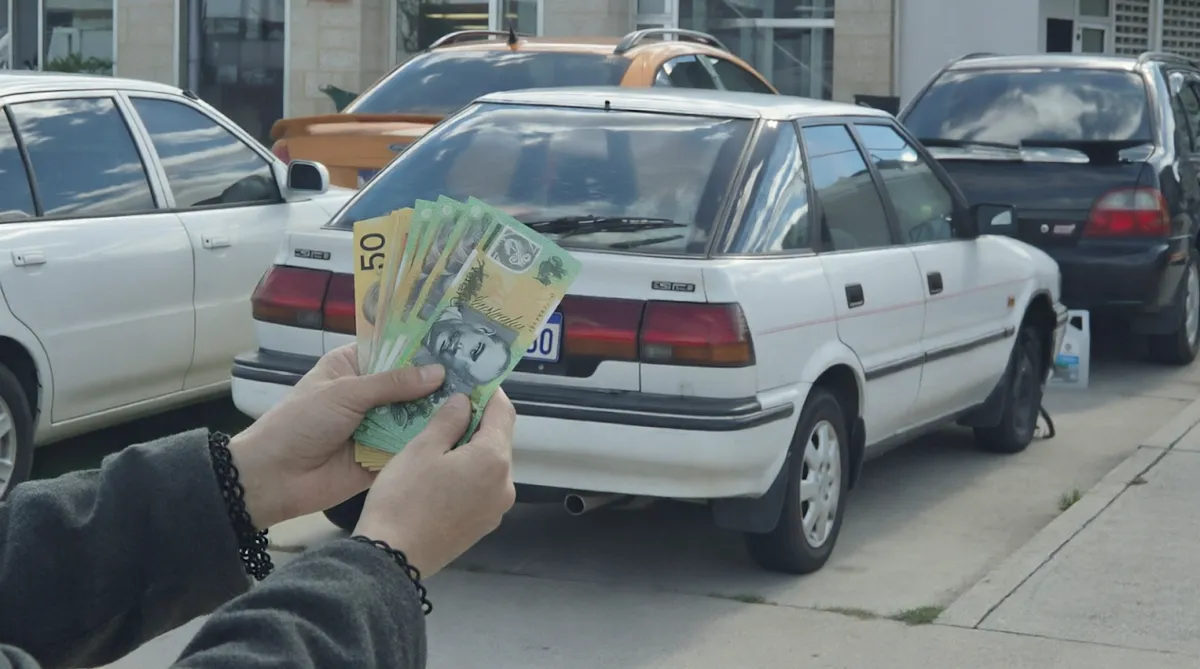 Cash counted out in front of a car after an iCar Removals car removal in Perth