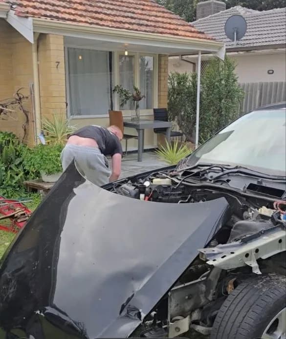 Close-up of a crumpled bonnet and damaged engine bay on a collision-damaged car collected in Perth
